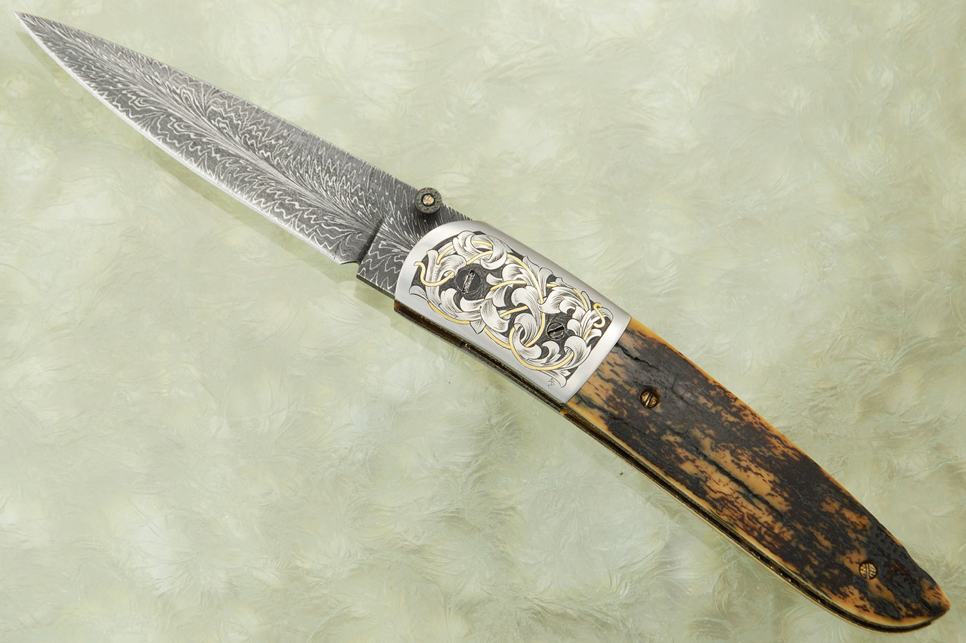 Feather Damascus Linerlock Folder with Mammoth Bark and Engraved Bolsters